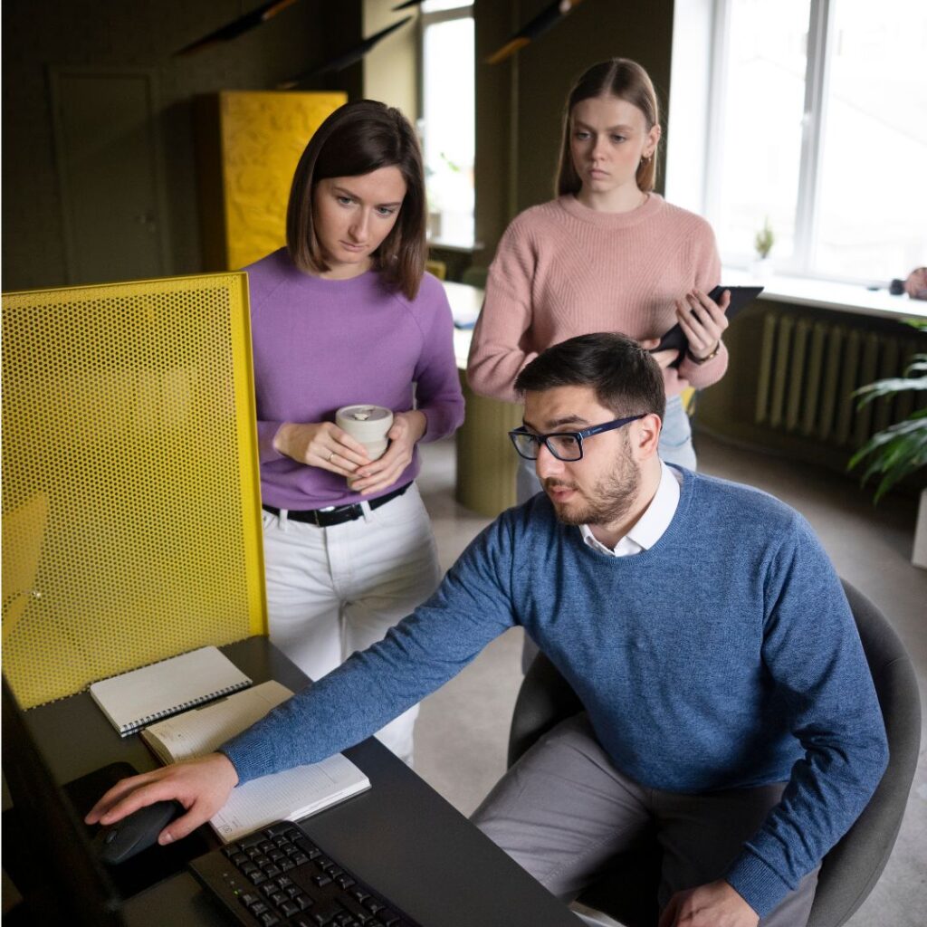 Equipo de ventas revisando juntos la información de sus clientes en la computadora: así se organiza el trabajo con Aspira CRM