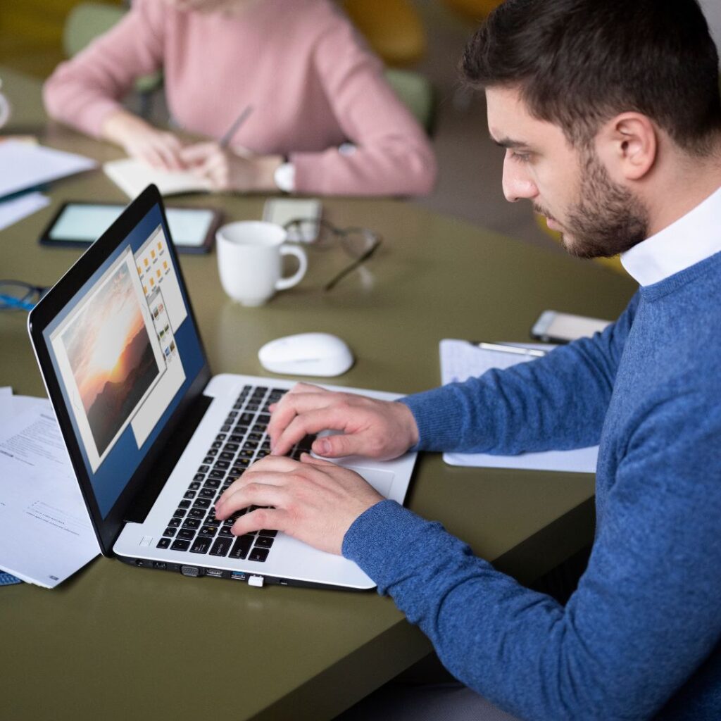 Programador trabajando en el diseño de un sitio en su laptop: así creamos páginas web con IA a medida